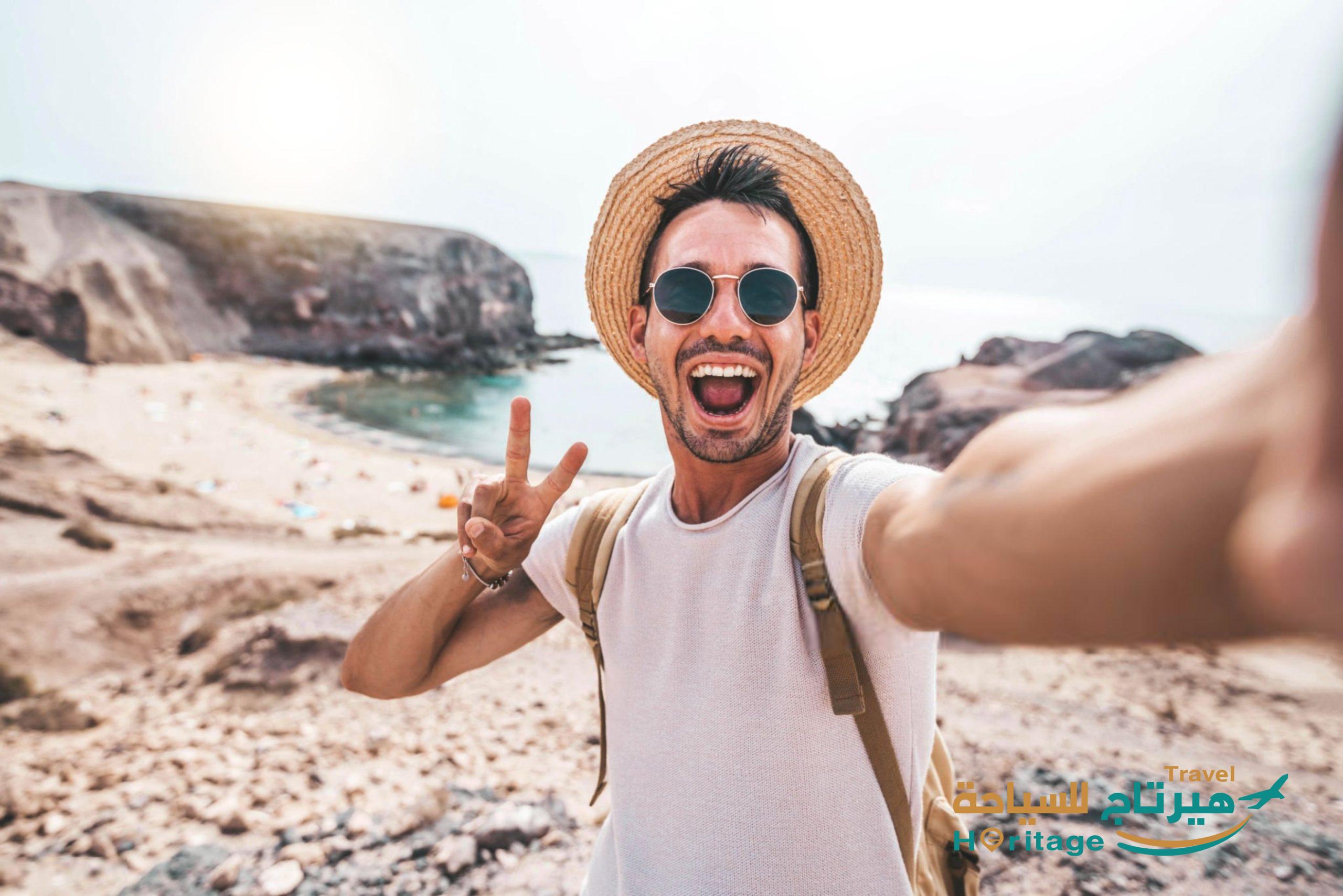 Young man with backpack taking selfie portrait on a mountain